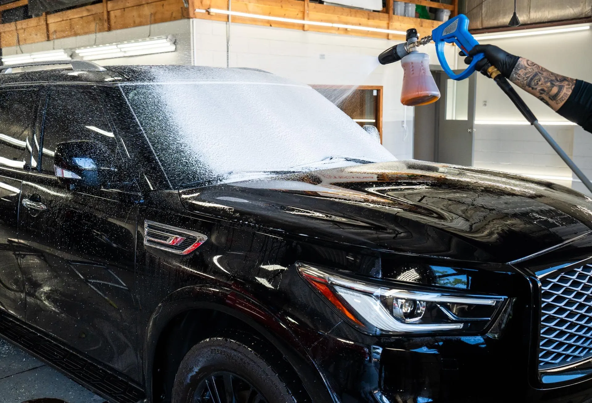 Foam cannon pass over a black Infiniti QX80 before decontamination