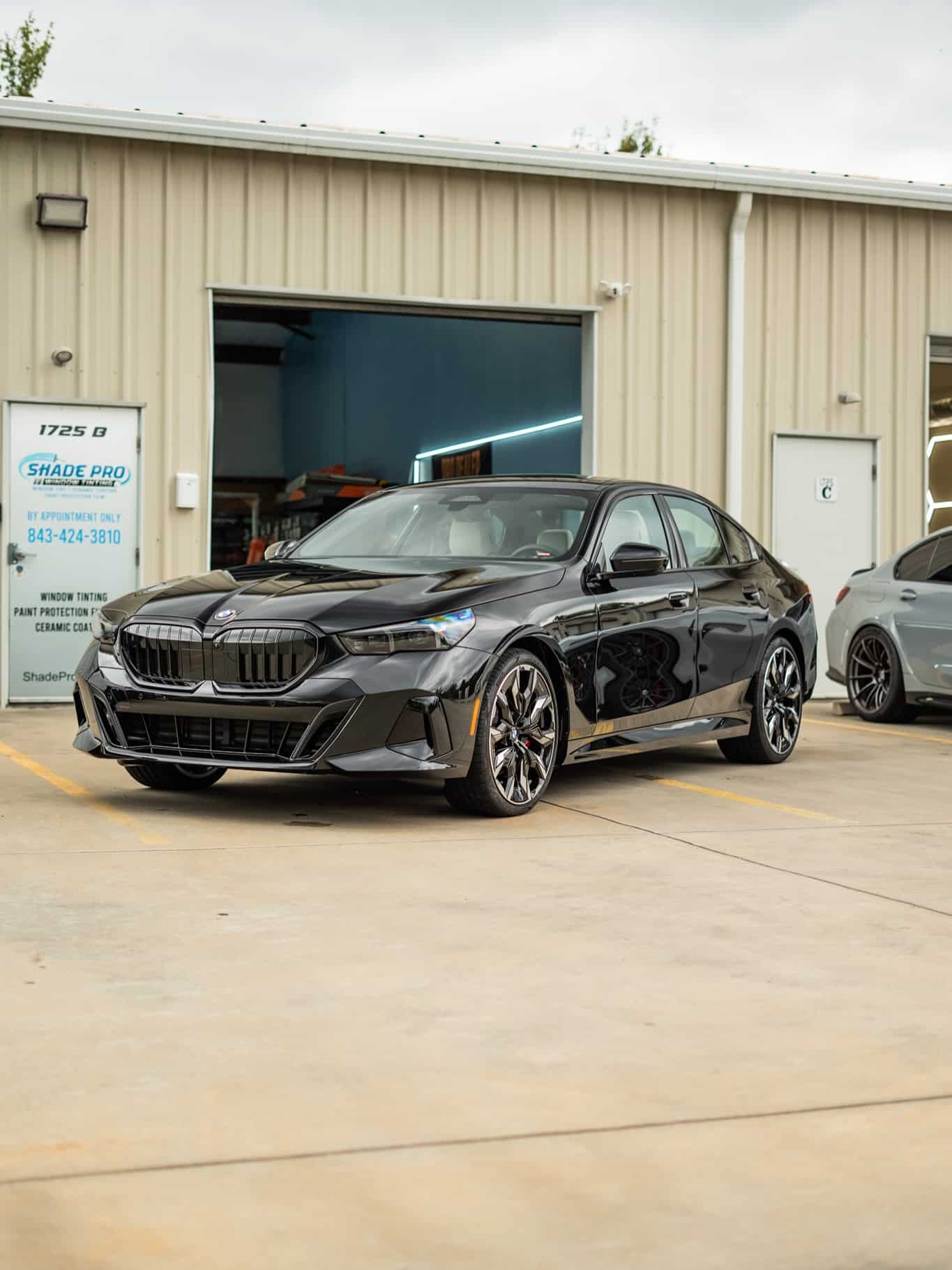 Black BMW 5 Series outside the shop